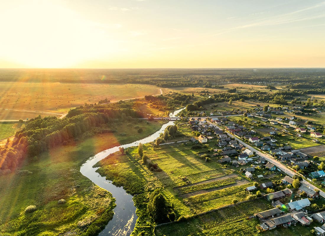 Williamston, NC - Aerial View of Homes Surrounded by Green Grass and Foliage with a River Running Through in the Small Town of Williamston North Carolina at Sunset
